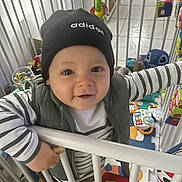 Lino participe au concours pour gagner de l'argent avec cette photo : toddler, child, beanie, adidas, striped_shirt, playpen, toys, smiling, indoor, colorful, baby, clothing, hand, face, person, play_area, plastic, floor_mat, cute, happy