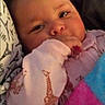 Serenity is registered to the contest to win money with this photo: baby, infant, child, portrait, face, eyes, smiling, curious, sitting, lying_down, blanket, clothing, pink, purple, colorful, stuffed_toy, textile, indoor, close_up, cozy
