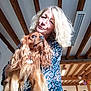 Roops a rejoint le concours — aidez-le/la à gagner de superbes lots ! woman, dog, indoor, blonde_hair, long_hair, pet, animal, person, ceiling, wooden_beams, fluorescent_light, holding, brown_dog, long_ears, smiling, portrait, casual, happy, love, candid