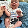 Liam is registered to the contest to win money with this photo: adult_hand, baby, blanket, child, cushion, cute, elephant_graphic, face, foot, hand, happy, indoors, infant, onesie, person, red_nail_polish, skin, smiling, soft_texture, toddler