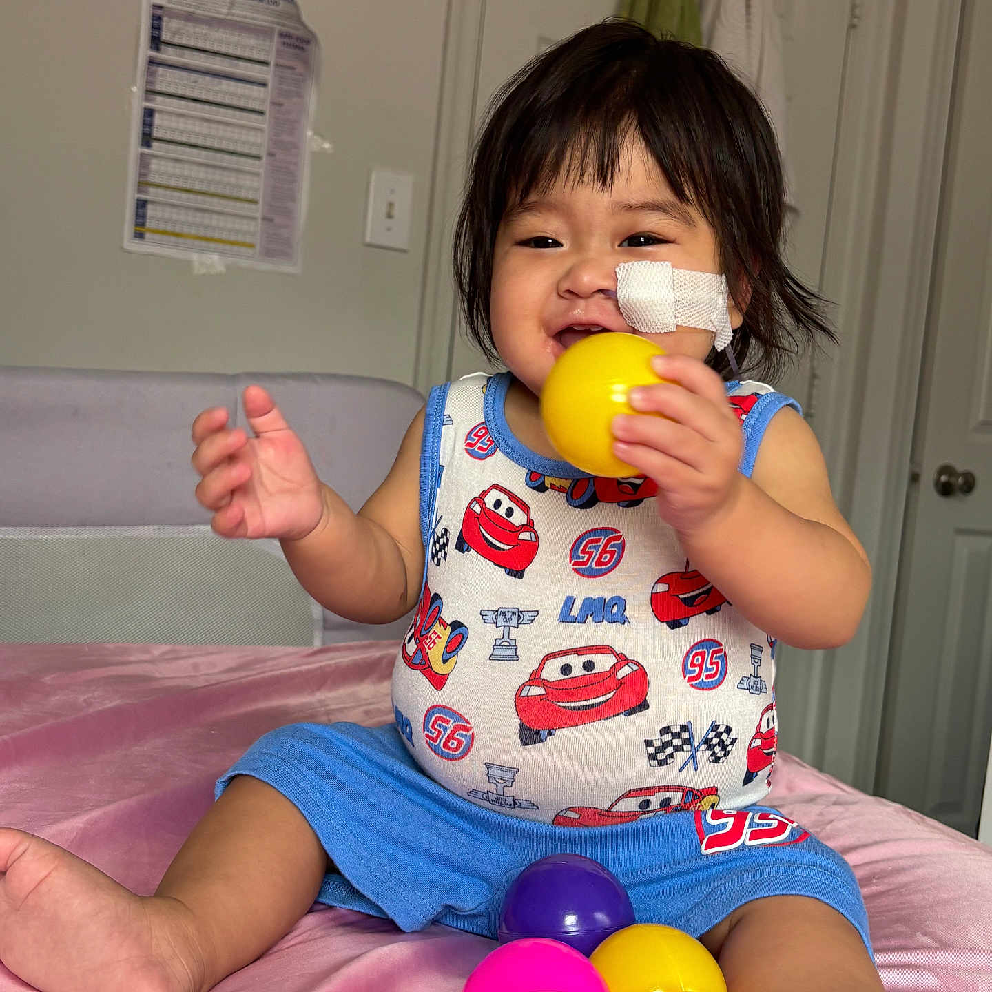 Anna Chin joined the competition — help win amazing prizes! toddler, child, baby, indoor, bed, pink, toy, ball, colorful, clothing, bandage, face, happy, smiling, sitting, shorts, shirt, hair, foot, room