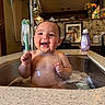 Kolter is registered to the contest to win money with this photo: baby, bath, sink, water, faucet, kitchen, smile, happy, child, foam, cleaning, soap, countertop, domestic, portrait, indoor, toddler, skin, face, expression