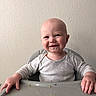baby, child, high_chair, food, messy, smiling, face, hands, infant, feeding, indoor, clothing, long_sleeve, table, expression, cute, portrait, skin, person, happy