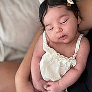 Giulia participe au concours pour gagner de l'argent avec cette photo : adorable, arms, baby, candid, closeup, cute, flower_hair_clip, hand, indoor, infant, peaceful, people, person, portrait, resting, skin, sleeping, soft_lighting, white_dress, young_child