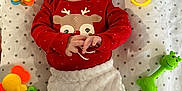 Lola participe au concours pour gagner de l'argent avec cette photo : baby, infant, red_clothing, headband, star_pattern, blanket, toy, colorful, smiling, cute, lying_down, hands, face, child, playtime, soft_pants, indoors, happy, cheerful, closeup