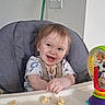 Luca is registered to the contest to win money with this photo: toddler, baby, high_chair, smiling, food, banana, toy, indoor, child, happy, face, person, tray, seat, clothing, hair, table, plastic_toy, play, infant