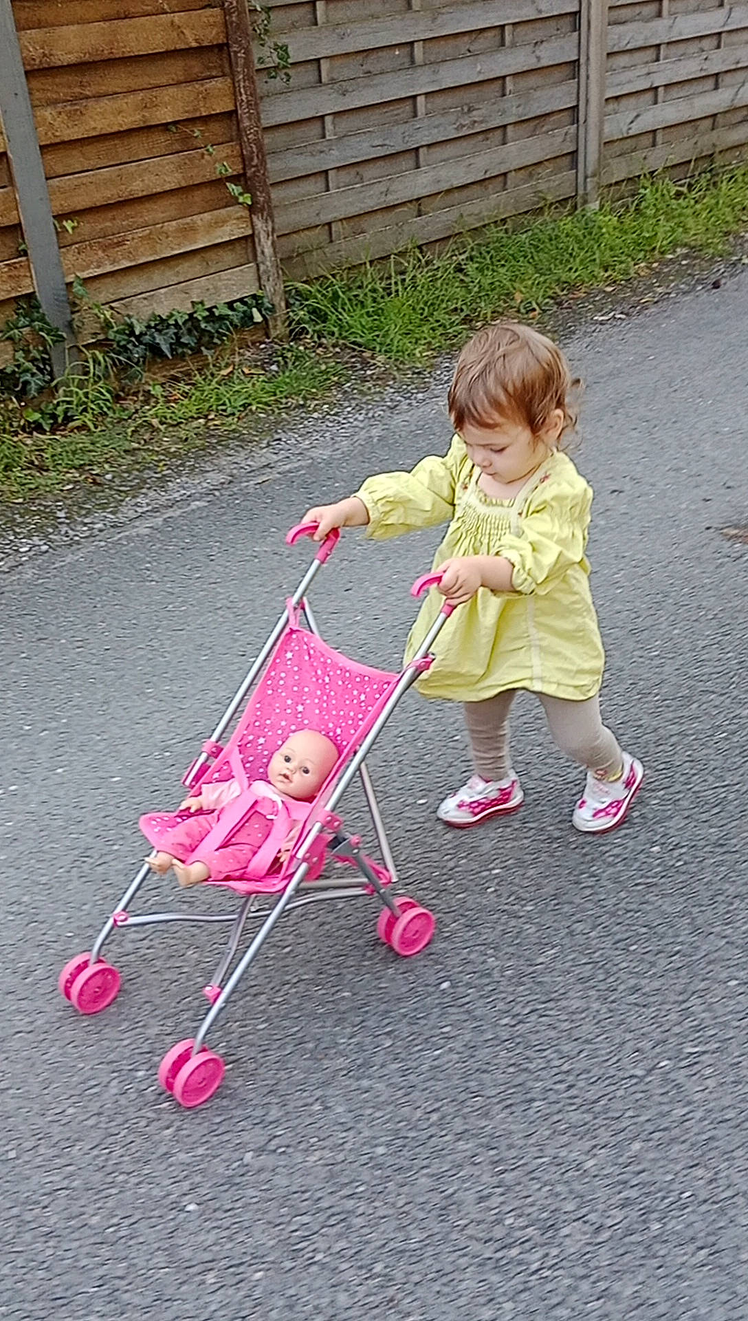 Julia a rejoint le concours — aidez-le/la à gagner de superbes lots ! baby, baby_carriage, baby_products, baby_toddler_clothing, cart, child, driveway, fence, fun, grass, leisure, magenta, people_in_nature, person, play, riding_toy, tire, toddler, vehicle, wheel