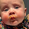 Ryker is registered to the contest to win money with this photo: baby, face, close_up, blue_eyes, messy, food, colorful_clothing, infant, cute, expression, skin, cheeks, mouth, person, portrait, child, indoors, bright_colors, curious, young