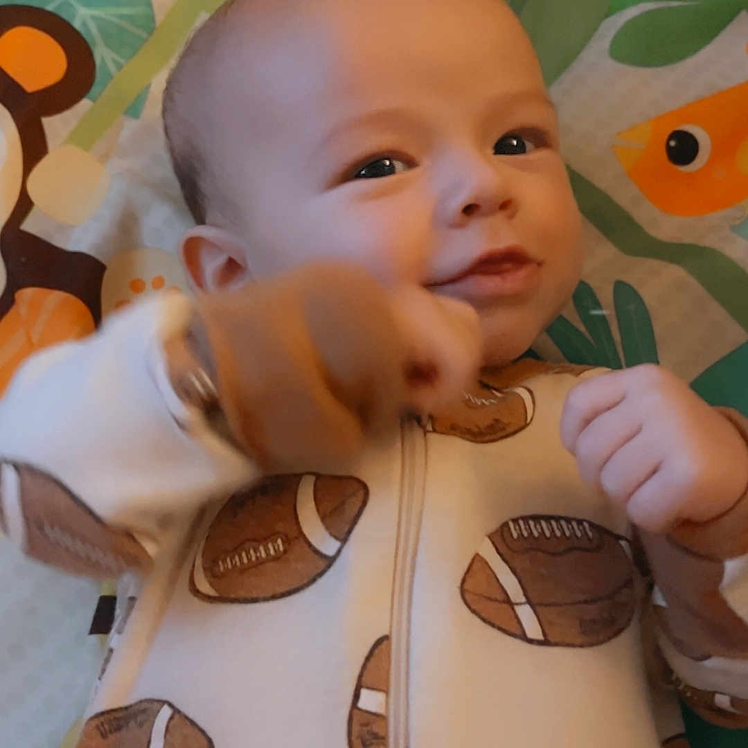 Brayden joined the competition — help win amazing prizes! americanfootball, americanfootballball, applique, baby, ball, blanket, bodypart, clothing, coat, face, finger, football, hand, head, knitwear, pattern, person, photography, portrait, sweater