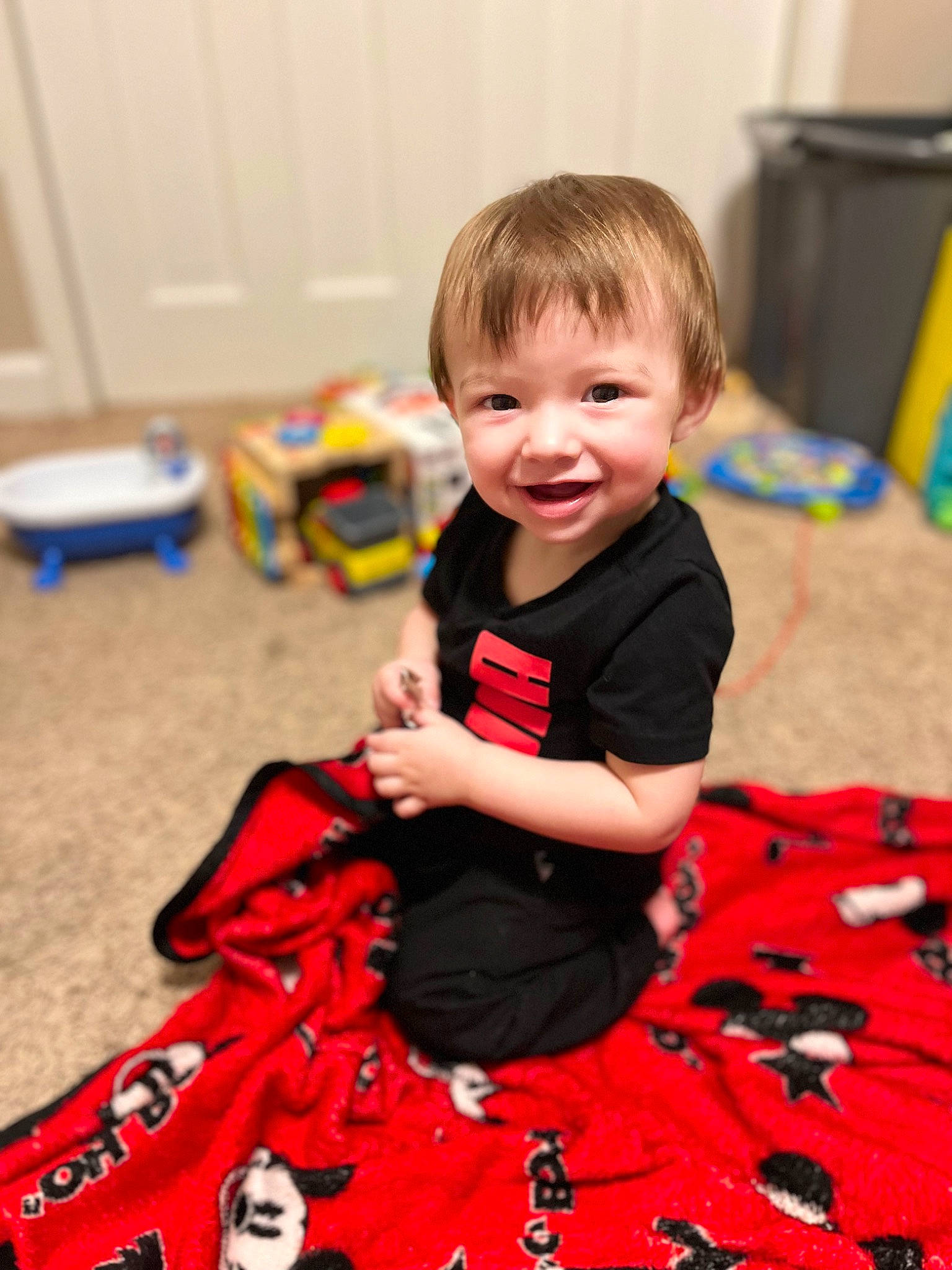 Jace is registered to the contest to win money with this photo: baby, baby_toddler_clothing, carmine, child, christmas, event, flooring, fun, happy, holiday, joy, leisure, pattern, person, play, red, room, sitting, sleeve, smile