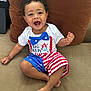 Josiah is registered to the contest to win money with this photo: 4th_of_july, baby, bow_tie, celebration, child, clothing, couch, face, feet, happy, holiday, indoor, person, portrait, red_white_blue, shirt, shorts, sitting, smiling, toddler