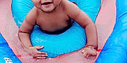 Josiah is registered to the contest to win money with this photo: baby, blue, child, curly_hair, cute, float, fun, happy, infant, inflatable, outdoor, person, playful, pool, recreation, skin, smiling, summer, swimming, water