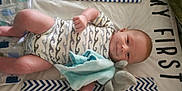 Mark is registered to the contest to win money with this photo: baby, baby_boy, baby_clothing, blanket, blue, child, cute, fabric, grey, home, infant, lying_down, onesie, pattern, sleeping_area, smiling, soft_toy, stuffed_toy, toddler, white