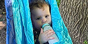 Selene joined the competition — help win amazing prizes! baby, baby_bottle, blue_hammock, casual_clothing, child, curly_hair, drinking, face, greenery, hammock, hand, milk, nature, outdoor, peaceful, portrait, relaxing, sunlight, toddler, tree