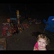 Selene joined the competition — help win amazing prizes! camping_chair, celebration, child, clothing, curly_hair, dark, dirt, fireworks, flash, fun, ground, happy, night, outdoor, party, person, small, smile, toddler, toy