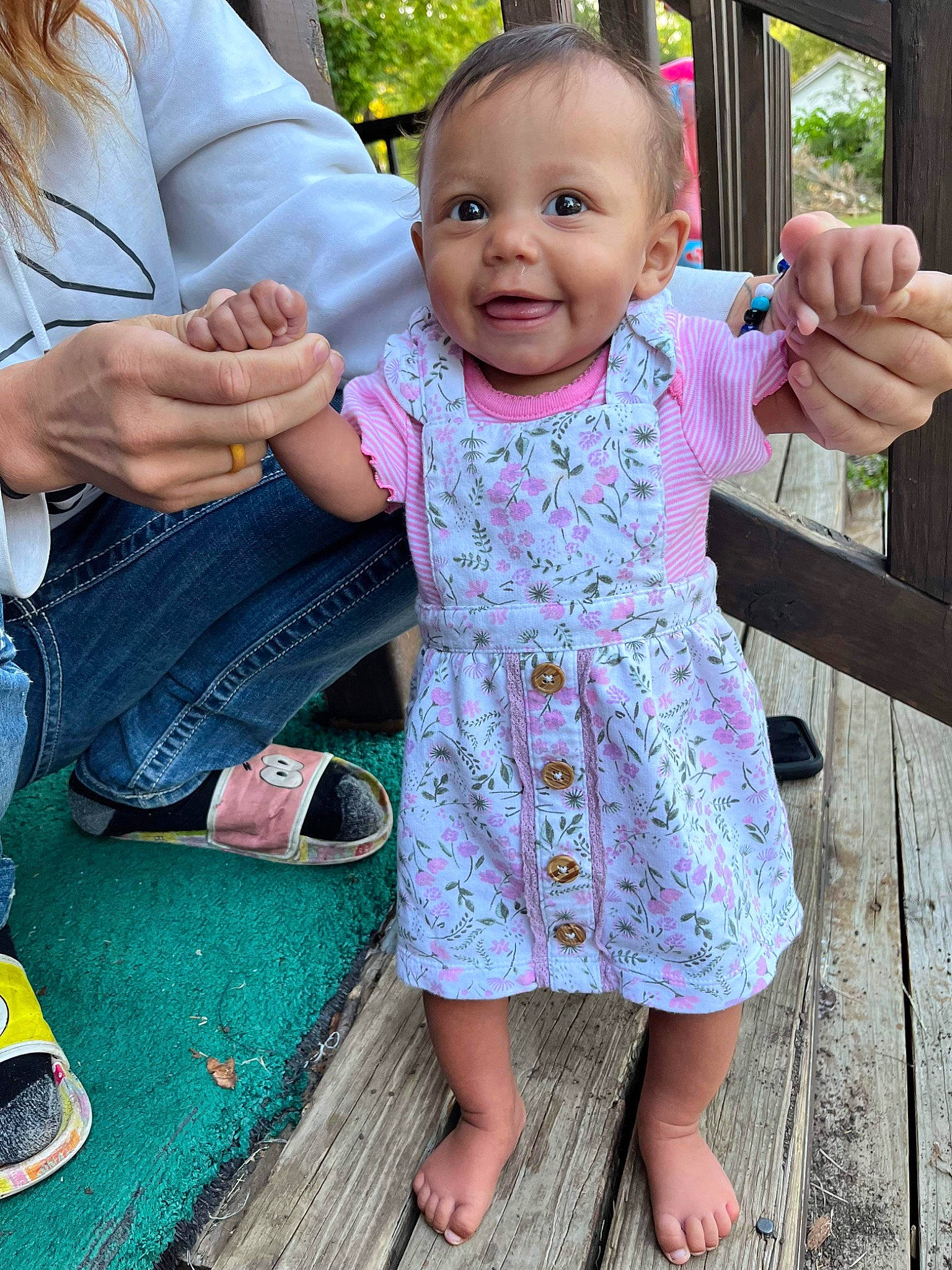 River is registered to the contest to win money with this photo: baby, baby_toddler_clothing, eye, face, facial_expression, finger, gesture, green, hand, happy, head, joint, joy, leaf, leg, person, photograph, pink, skin, sleeve