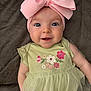 Shia is registered to the contest to win money with this photo: baby, child, pink_bow, green_dress, floral_embroidery, smiling, blue_eyes, infant, cute, headband, tulle_skirt, happy, portrait, closeup, soft_texture, laying_down, adorable, baby_fashion, indoor, person
