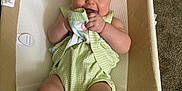 Shia joined the competition — help win amazing prizes! baby, infant, pink_bow, green_outfit, socks, baby_seat, carpet, smiling, cute, child, hand, face, portrait, indoor, happy, clothing, fabric, seat, skin, person