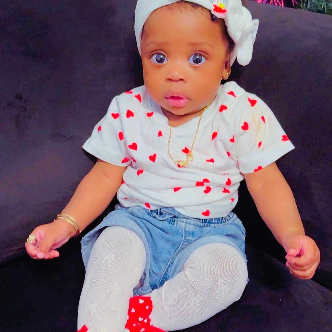 Eyimofe joined the competition — help win amazing prizes! baby, bows, child, christmas_tree, couch, curious_expression, cute, decorations, denim_shorts, fashion, gold_jewelry, headband, heart_pattern, indoor, infant, person, portrait, red_shoes, sitting, white_tights
