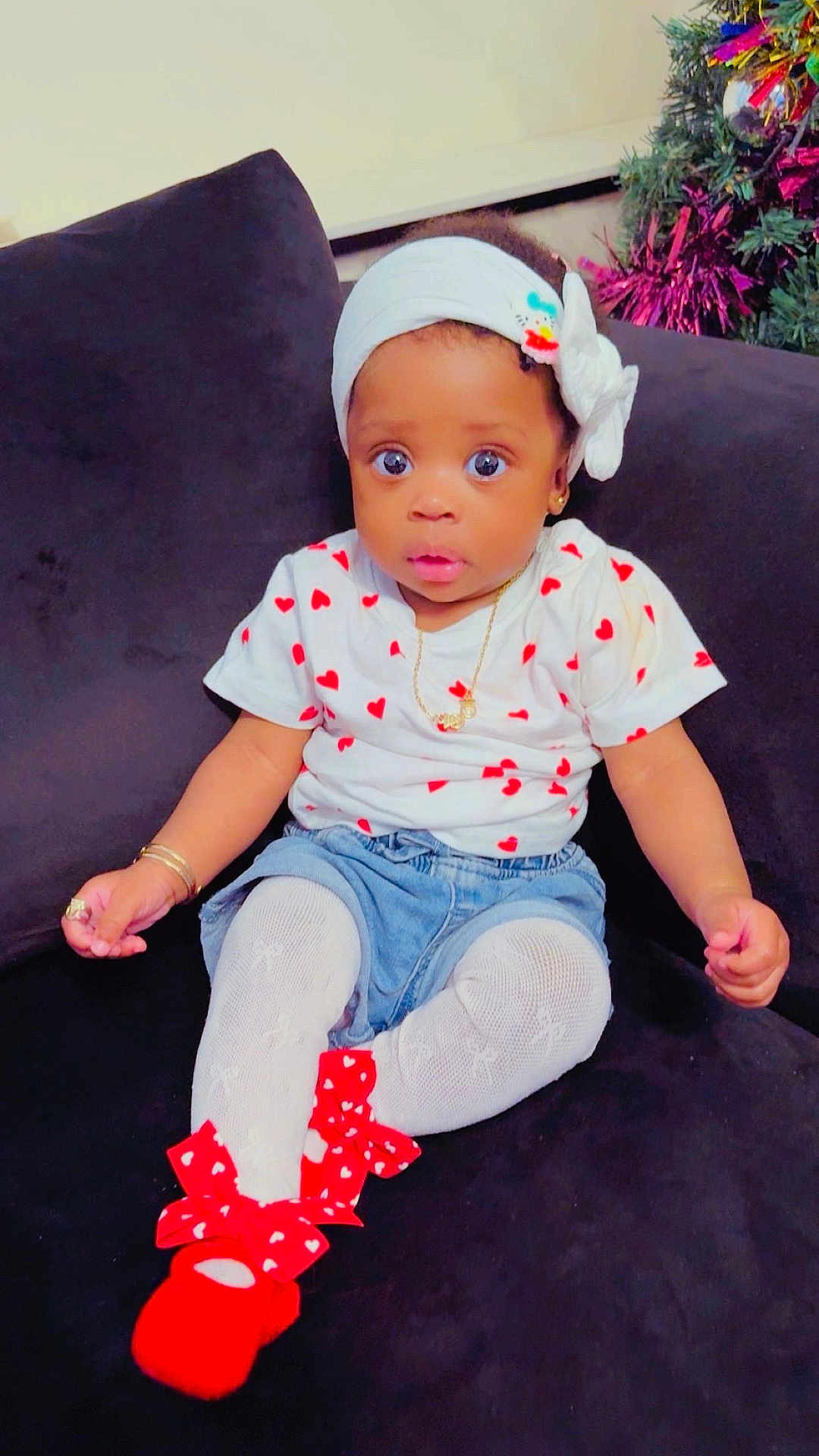Eyimofe joined the competition — help win amazing prizes! baby, child, infant, sitting, heart_pattern, headband, white_tights, red_shoes, bows, denim_shorts, gold_jewelry, couch, indoor, christmas_tree, decorations, curious_expression, portrait, cute, person, fashion