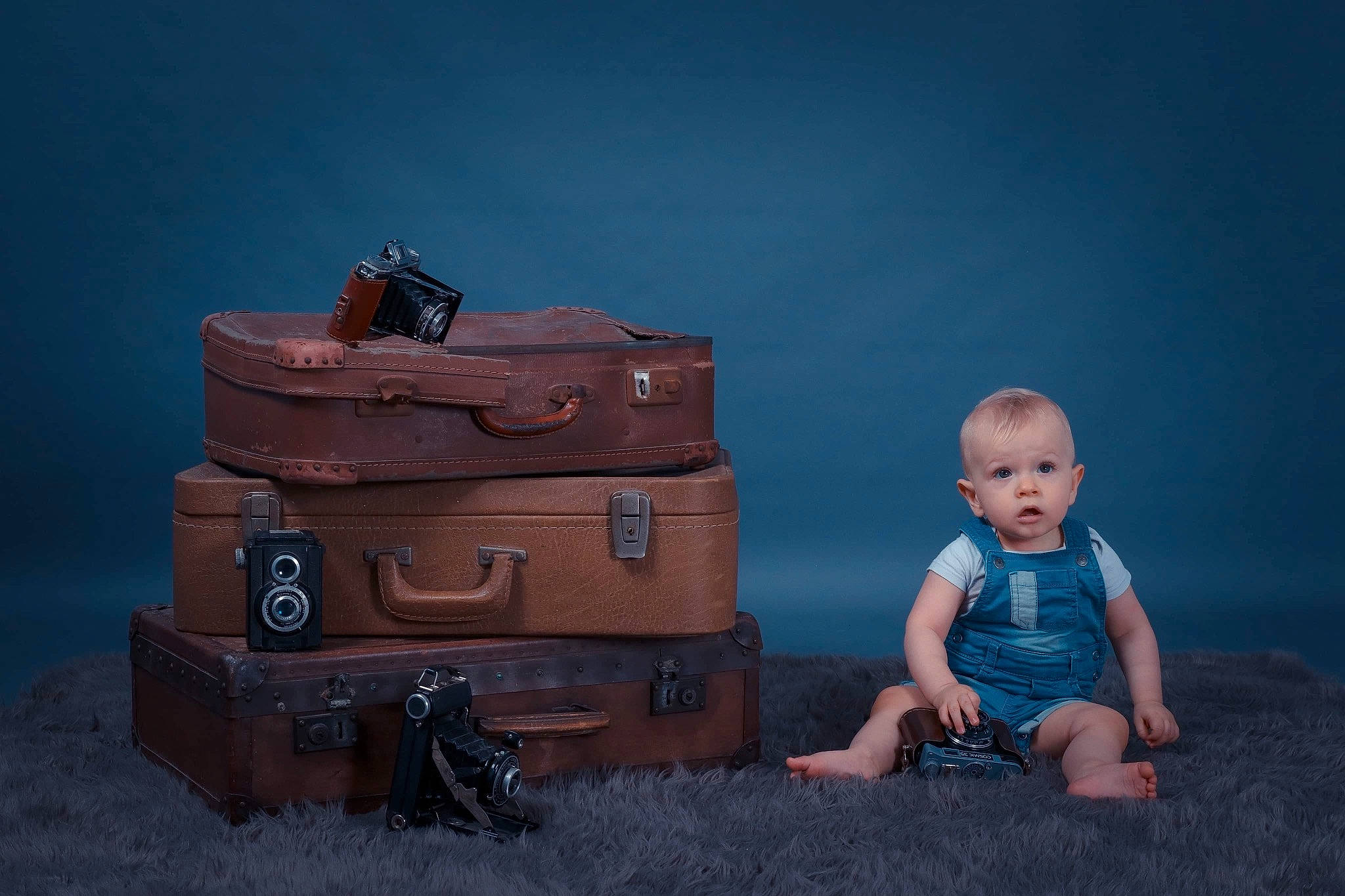 Taïron participe au concours pour gagner de l'argent avec cette photo : baby, baggage, blue, box, brown, child, fashion_accessory, flash_photography, furniture, luggage_and_bags, person, photography, shoe, sitting, still_life, still_life_photography, suitcase, surprise, toddler, travel