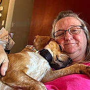 Dixie joined the competition — help win amazing prizes! woman, glasses, dog, snuggling, indoor, pink_shirt, brown_dog, relaxed, face, pet, home, couch, comfortable, smiling, casual, collar, light, human, affection, closeup