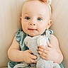 Margaret is registered to the contest to win money with this photo: baby, child, blue_eyes, bow, stuffed_animal, plush_toy, soft_toy, cute, portrait, infant, light_background, clothing, dress, hand, face, skin, furniture, seated, looking_at_camera, adorable