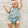 Margaret joined the competition — help win amazing prizes! baby, child, infant, smiling, blue_outfit, headband, lying_down, quilt, textured_bedspread, happy, cute, barefoot, portrait, indoor, person, young_child, raised_arms, clothing, soft_lighting, closeup