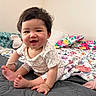 baby, bed, blanket, child, clothing, colorful, cozy, cute, face, happy, home, indoor, infant, person, pillow, portrait, sitting, smiling, soft, toy