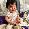 toddler, baby, smiling, happy, bottle, clothing, blanket, indoors, playpen, laundry_basket, bracelet, pajamas, person, child, cute, portrait, sitting, hair, expression, cozy
