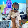 baby, sunglasses, adult_hand, television, woman, carpet, room, home, furniture, smile, clothing, person, technology, indoor, playful, holding, cord, remote_control, couch, happy