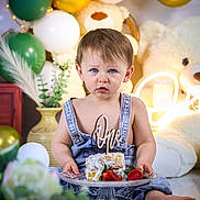 Raphael a rejoint le concours — aidez-le/la à gagner de superbes lots ! baby, child, birthday, cake, balloons, teddy_bear, denim_overalls, blue_eyes, celebration, first_birthday, plate, strawberries, decorations, indoor, cute, portrait, smash_cake, sitting, young_child, festive