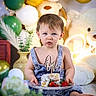 baby, child, birthday, cake, balloons, teddy_bear, denim_overalls, blue_eyes, celebration, first_birthday, plate, strawberries, decorations, indoor, cute, portrait, smash_cake, sitting, young_child, festive