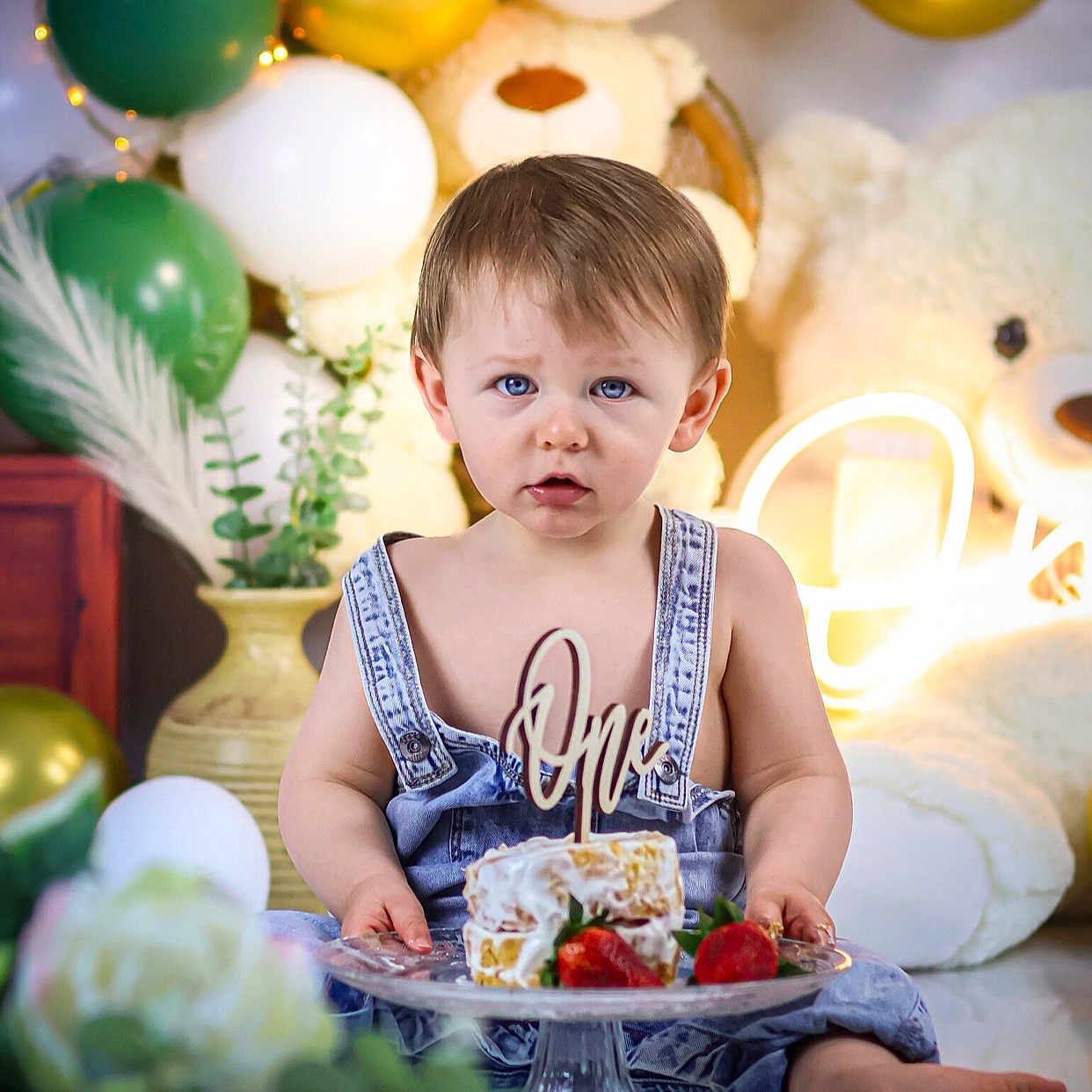Raphael a rejoint le concours — aidez-le/la à gagner de superbes lots ! baby, child, birthday, cake, balloons, teddy_bear, denim_overalls, blue_eyes, celebration, first_birthday, plate, strawberries, decorations, indoor, cute, portrait, smash_cake, sitting, young_child, festive