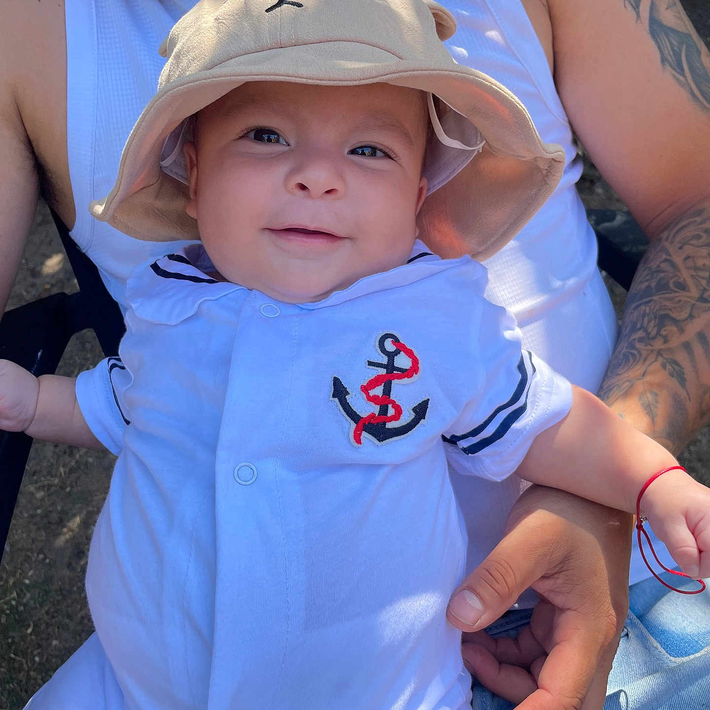Romero Vasco a rejoint le concours — aidez-le/la à gagner de superbes lots ! adult, arm, baby, casual, child, closeup, cute, family, happy, hat, holding, infant, nature, outdoor, person, portrait, smiling, sunlight, tattoo, white_clothing