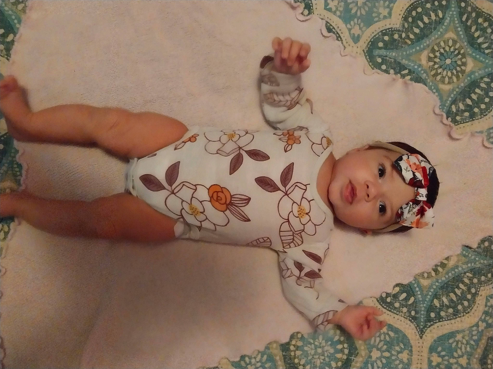 Genesis is registered to the contest to win money with this photo: baby, baby_toddler_clothing, chest, dress, eye, fawn, flooring, head, headgear, headwear, human_body, infant_bodysuit, iris, linens, neck, pattern, person, skin, sleeve, thigh