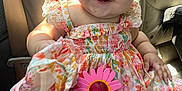Azariah is registered to the contest to win money with this photo: baby, child, smile, braids, hair_clips, dress, floral_pattern, sunglasses, pink, car_seat, sunlight, happy, cute, infant, portrait, clothing, hand, seat, indoors, person