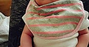 Jurnie is registered to the contest to win money with this photo: baby, bib, child, closeup, clothing, comfort, curious, expression, face, feet, hand, head, indoor, infant, lap, legs, person, sitting, skin, striped