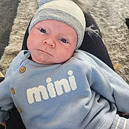 Oaklay joined the competition — help win amazing prizes! baby, infant, child, blue_clothing, hat, pom_pom, face, eyes, person, lap, carpet, texture, cozy, casual, indoor, portrait, cute, warm, knitwear, button