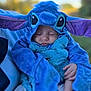 Lillianna is registered to the contest to win money with this photo: baby, child, costume, blue, stitch, sleeping, outdoor, person, cute, soft, plush, ears, face, hands, clothing, portrait, infant, cozy, nature, blurred_background