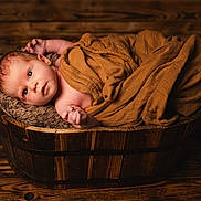 Louise participe au concours pour gagner de l'argent avec cette photo : newborn, baby, infant, wrapped, blanket, wooden_bucket, wood_floor, portrait, cute, small, child, resting, cozy, warm, soft, face, lying_down, indoors, peaceful, skin