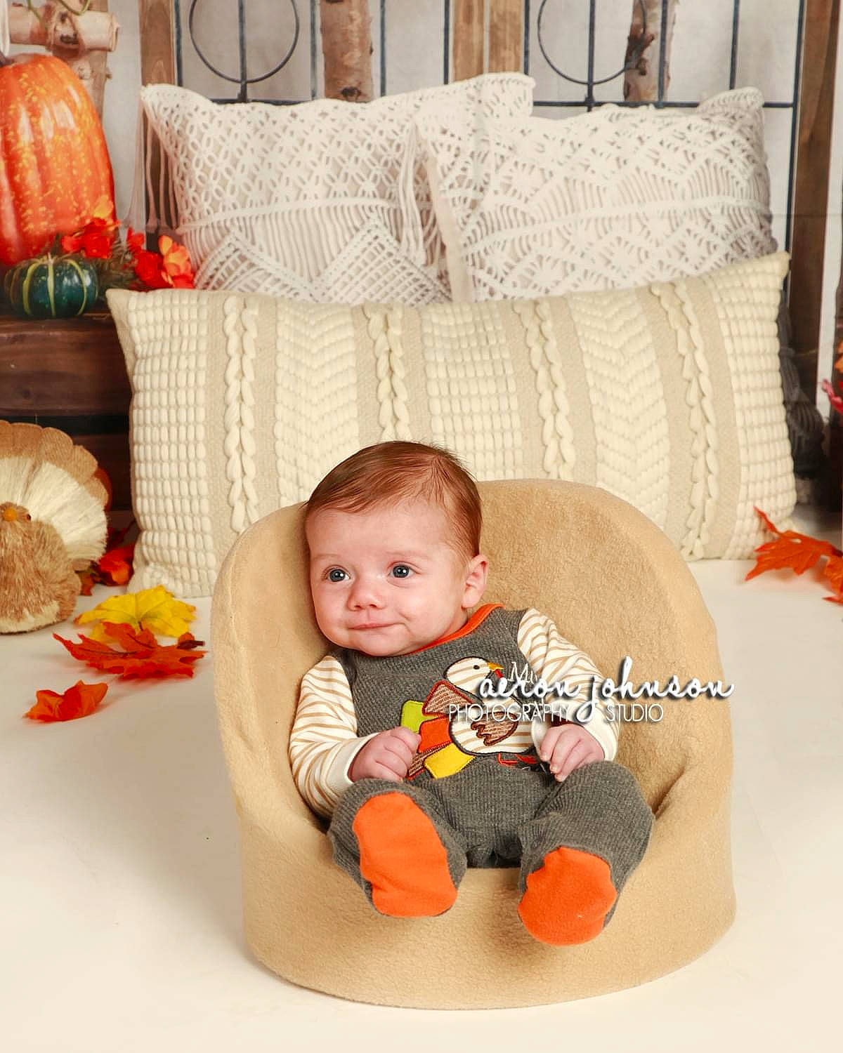 Grayson is registered to the contest to win money with this photo: baby, baby_products, baby_toddler_clothing, baby_toys, child, comfort, couch, floor, flooring, hardwood, living_room, orange, person, product, room, sitting, stuffed_toy, textile, toddler, toy
