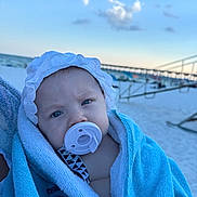 Amorina joined the competition — help win amazing prizes! baby, pacifier, towel, beach, sky, cloud, pier, hat, infant, child, blue, white, outdoor, sand, person, portrait, headwear, closeup, blanket, summer