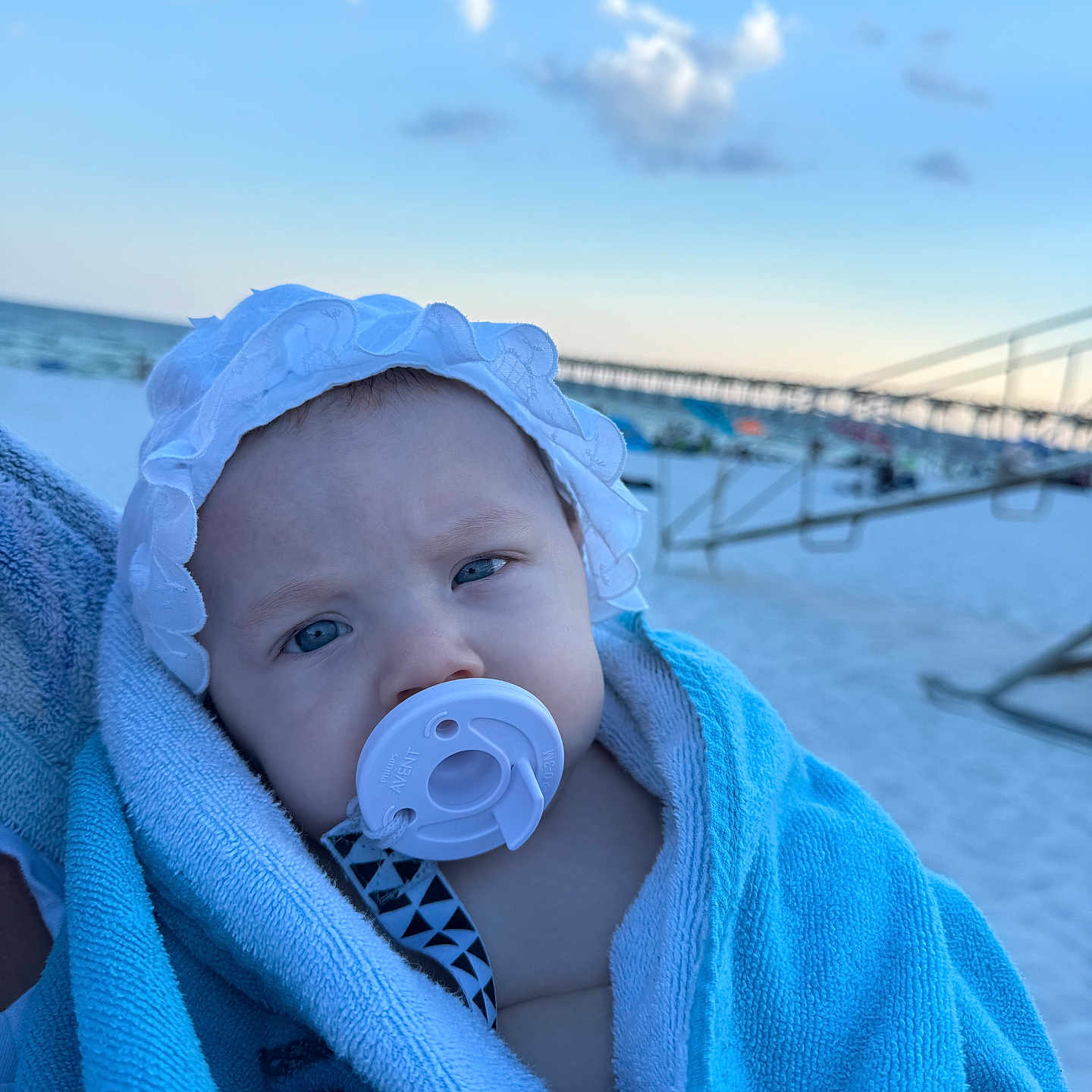 Amorina joined the competition — help win amazing prizes! baby, beach, blanket, blue, child, closeup, cloud, hat, headwear, infant, outdoor, pacifier, person, pier, portrait, sand, sky, summer, towel, white