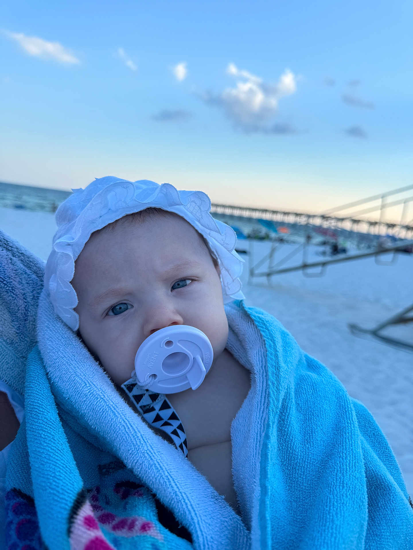 Amorina joined the competition — help win amazing prizes! baby, pacifier, towel, beach, sky, cloud, pier, hat, infant, child, blue, white, outdoor, sand, person, portrait, headwear, closeup, blanket, summer