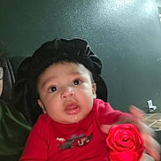 Keshaun joined the competition — help win amazing prizes! baby, black_bonnet, child, curious, cute, drool, face, furniture, hand, holding, indoors, infant, light, person, portrait, red_shirt, rose, wall, wide_eyes, young