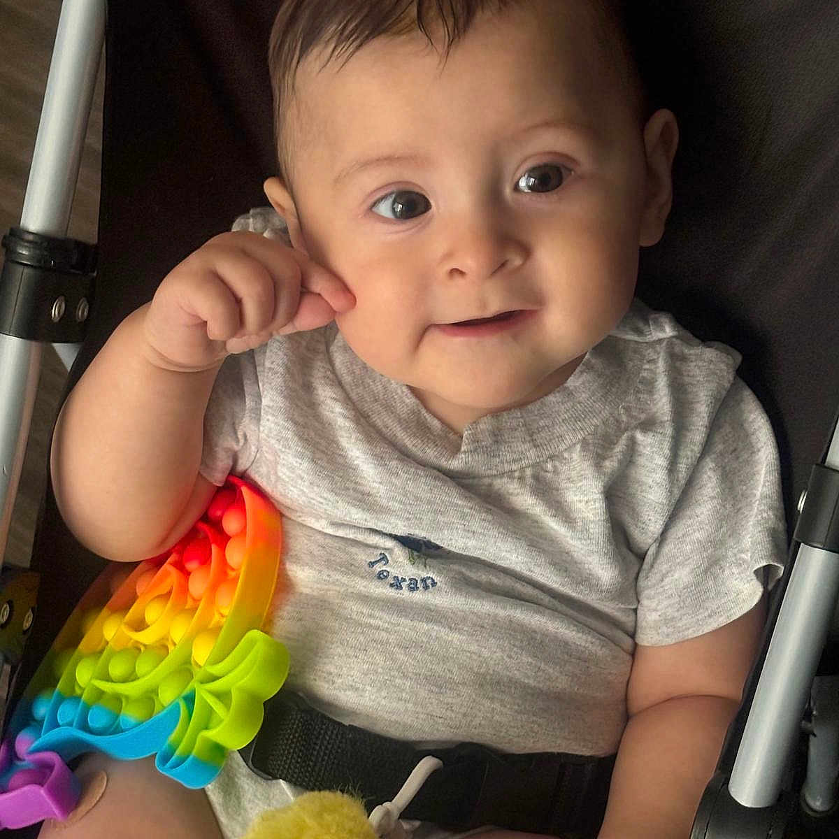 Eliott Jonás Palma is registered to the contest to win money with this photo: baby, brown_hair, child, close_up, face, gray_shirt, happy, indoors, infant, pop_it, portrait, rainbow, seatbelt, sitting, smiling, stroller, stuffed_duck, toy, wide_eyed, yellow_duck