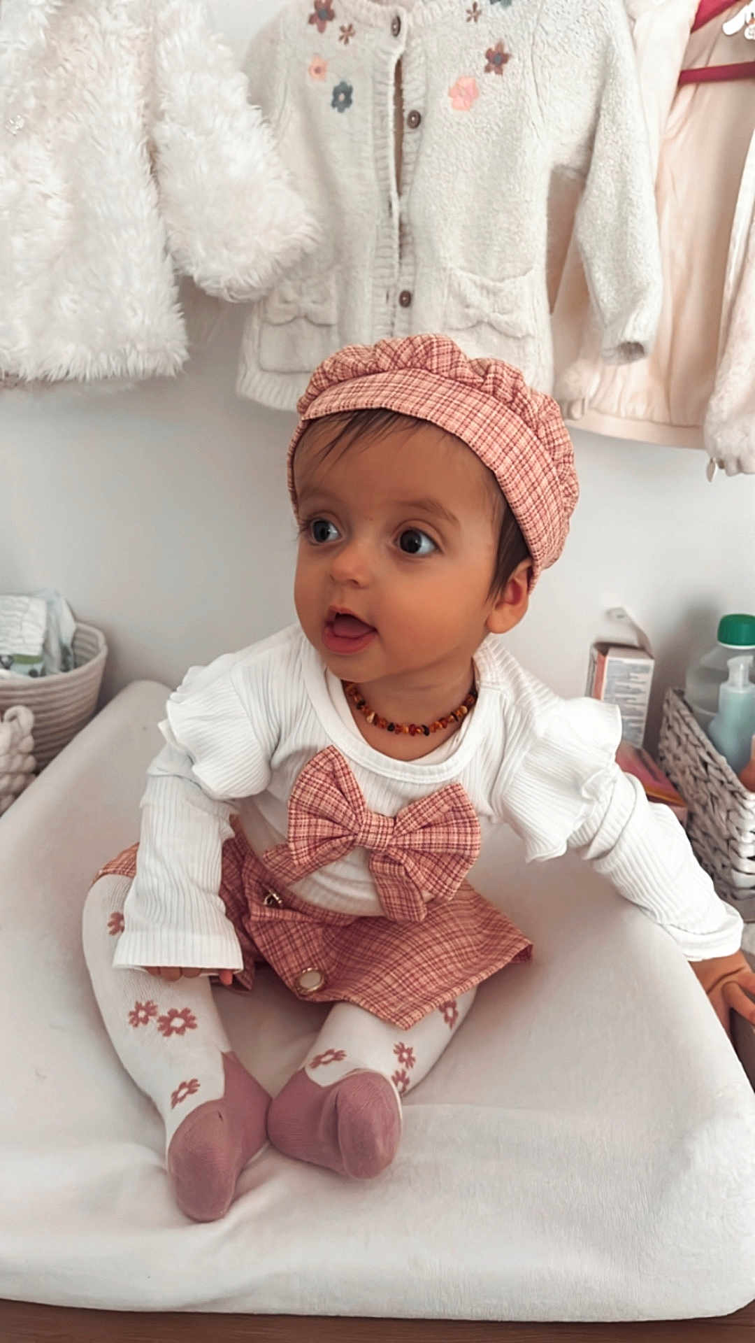 Júlia participe au concours pour gagner de l'argent avec cette photo : baby, child, infant, plaid, hat, bow, white_clothing, pink_clothing, sitting, cushion, nursery, clothes, tights, pattern, cute, portrait, indoor, face, expression, accessory