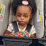 Kalaya is registered to the contest to win money with this photo: toddler, child, stroller, toy, pop_it, sunglasses, headband, pink, curly_hair, seatbelt, gray, baby, infant, play, outdoor, cute, person, seat, young_child, casual