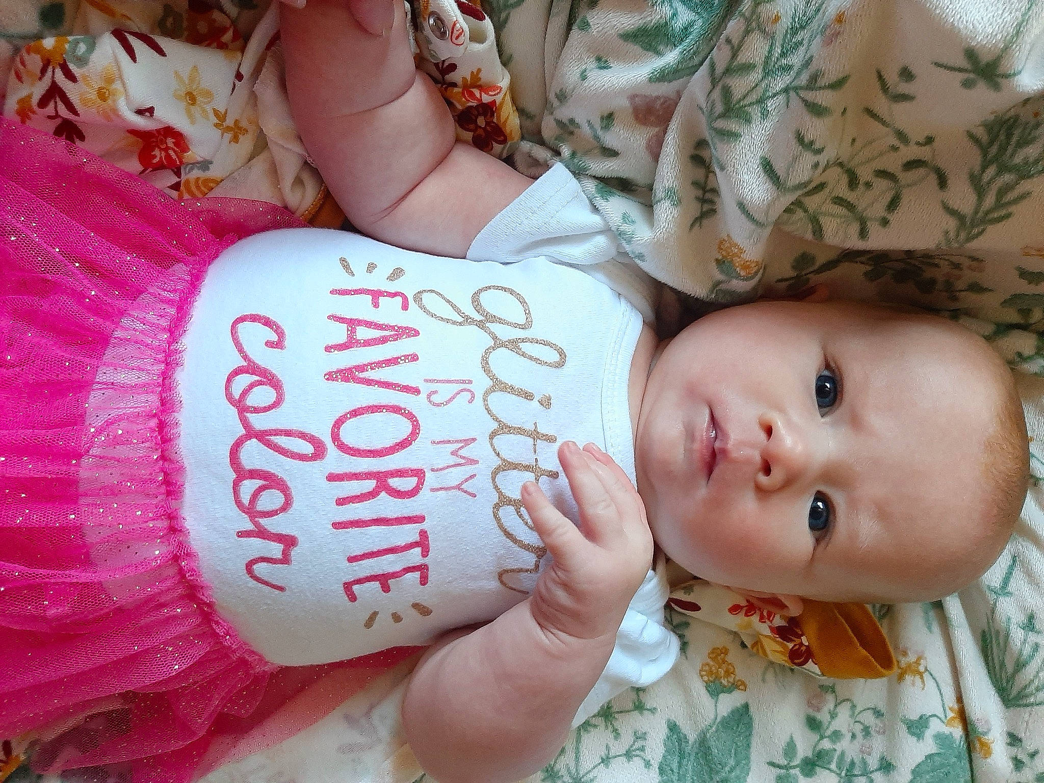 Ellora is registered to the contest to win money with this photo: arm, baby, baby_toddler_clothing, cheek, child, eyelash, finger, hair, hairstyle, hand, head, human_body, nail, organ, pattern, people, person, pink, skin, toddler